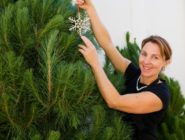 Owner of St Nicholas Christmas Trees putting a decoration on a fresh Christmas tree a the Old Bus Depot Markets