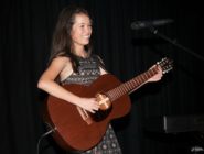 Old Bus Depot Markets busker, Lucy Sugerman with her guitar