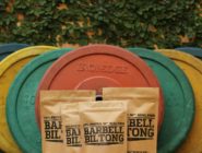 Bags of Barbell Biltong resting against weight barbells